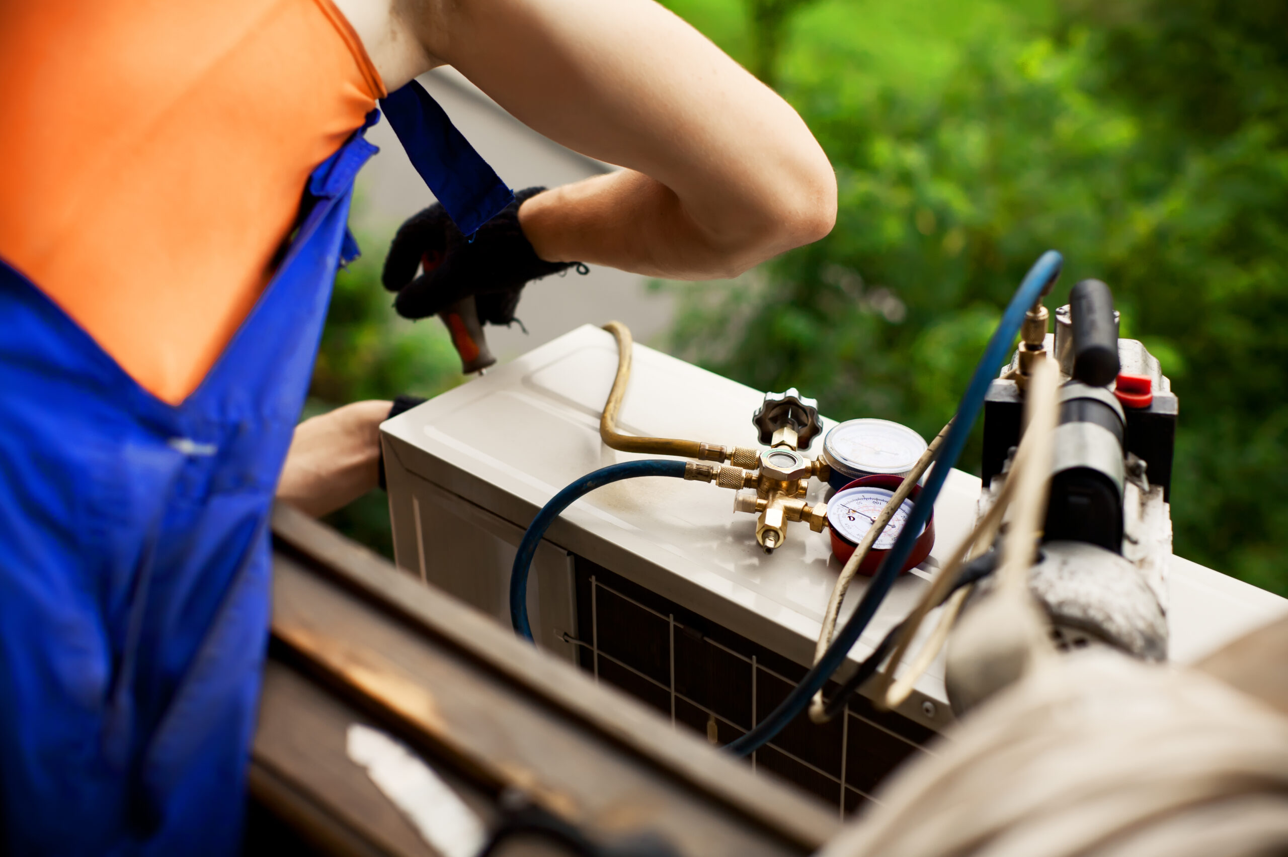 A person working on an air conditioner unit.
